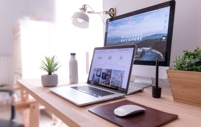 MacBook Pro on table beside white iMac and Magic Mouse