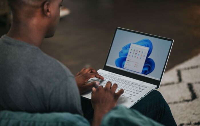 man in gray long sleeve shirt using Windows 11 computer