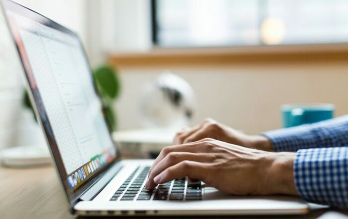 person typing on silver Macbook